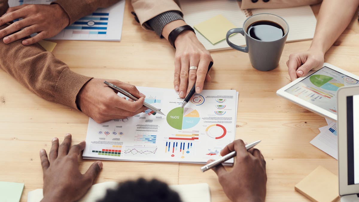 Équipe en réunion autour d'un écran dans un bureau moderne